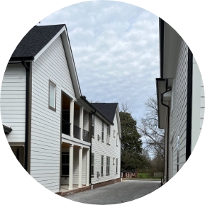View of an apartment complex from the driveway between two sets of buildings, highlighting M2 Group's multifamily development work.