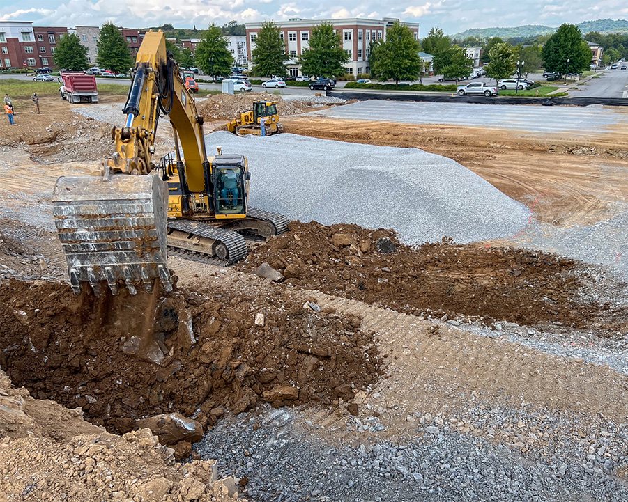 Heavy equipment actively working the land on a large-scale development site, showcasing M2 Group's management capabilities