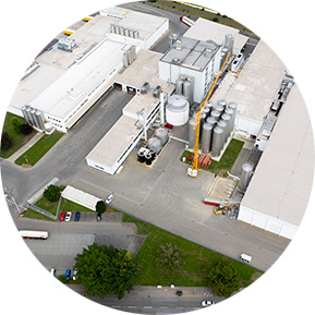 Aerial view of a large manufacturing facility with silos and industrial equipment, highlighting industrial production infrastructure