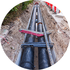 Construction site with large water pipes laid in a trench, showcasing water infrastructure development